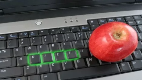 4234673 the word diet on laptop computer keyboard glowing in green with apple beside it