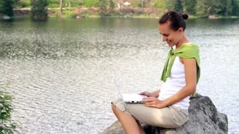 Stock footage a young woman chatting on laptop outdoors